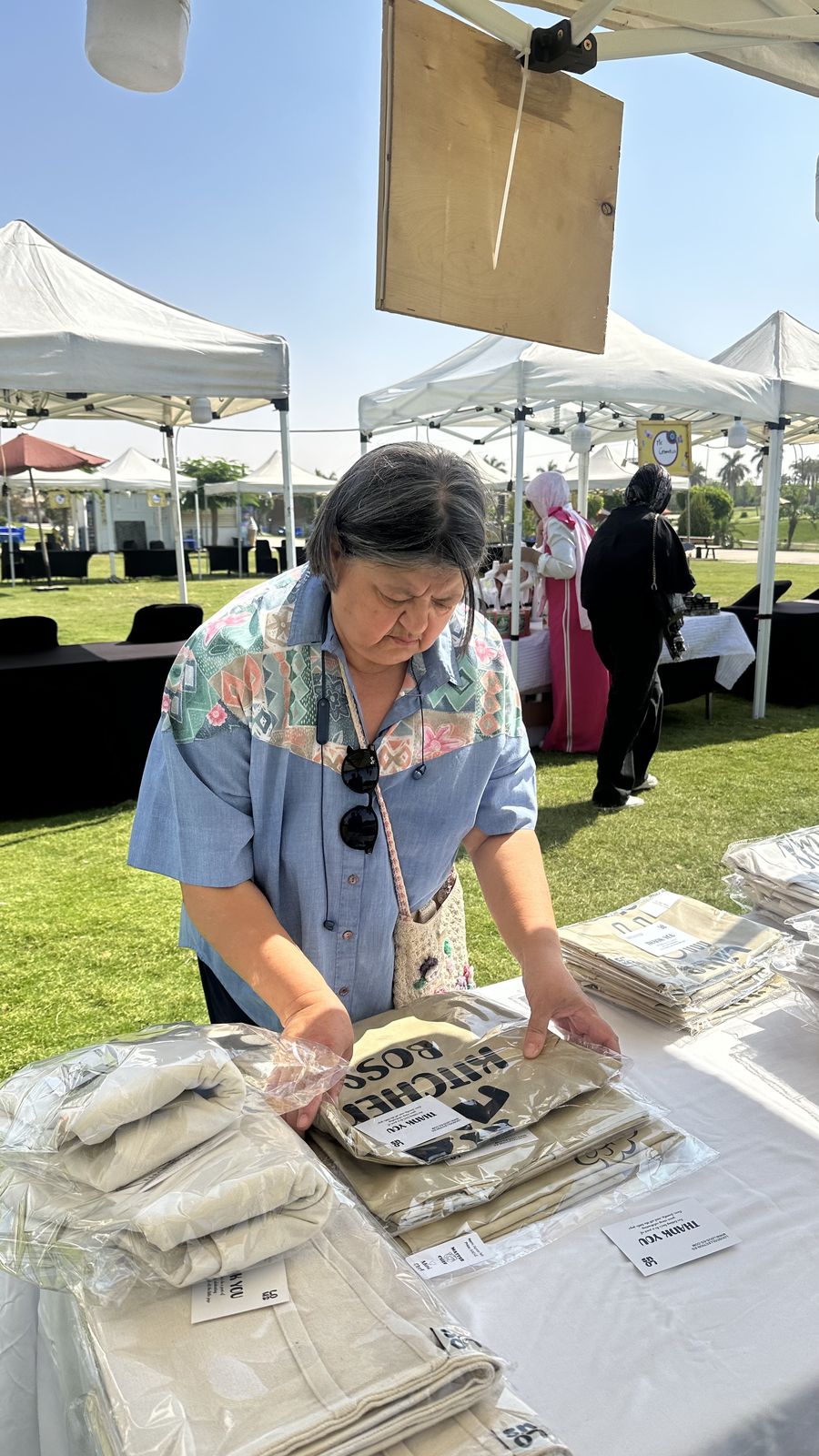 Teta Lolou arranging pieces at a Lou's bazaar stand