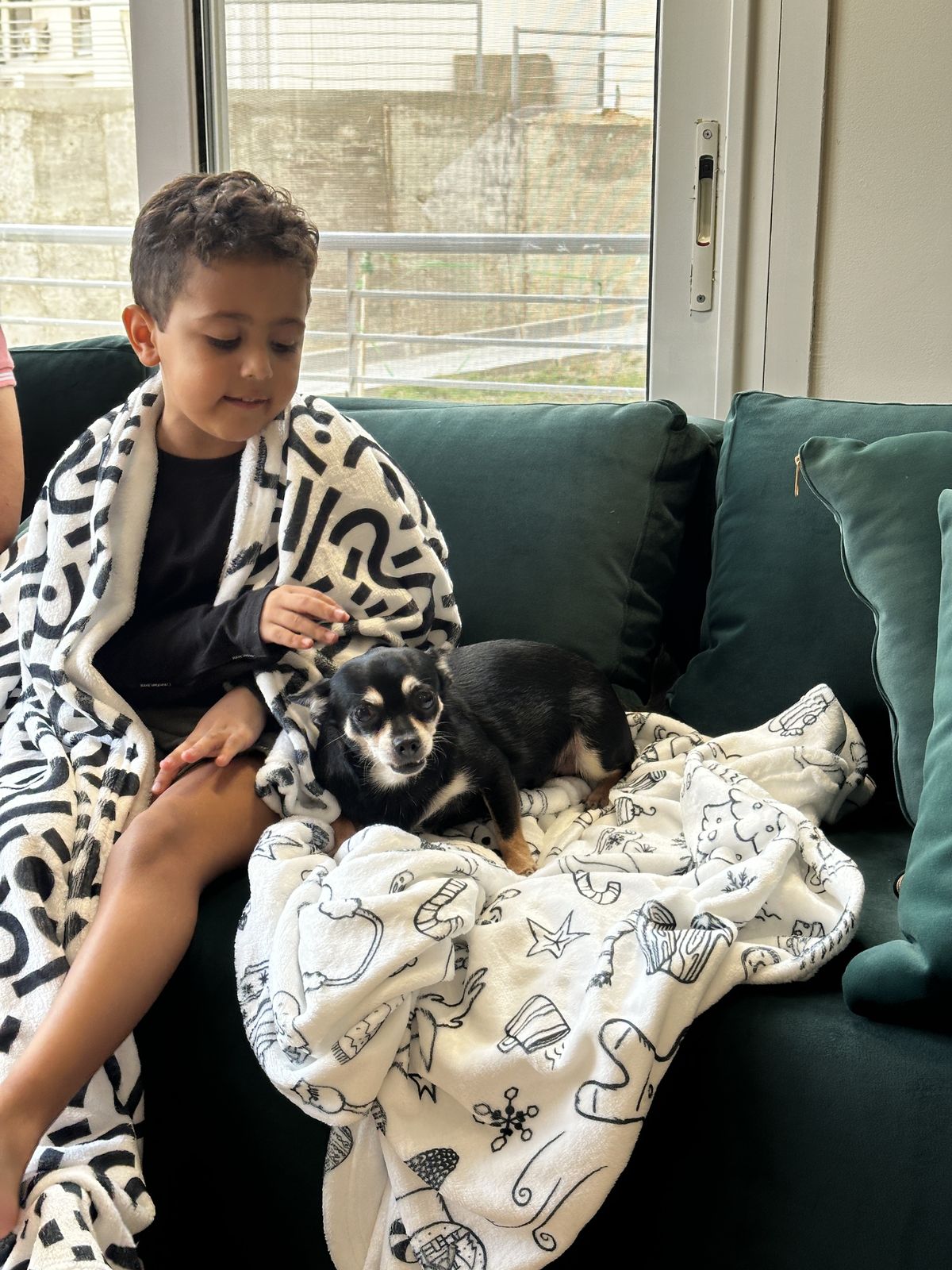 Grandson wrapped in a Lou's blanket with the family dog