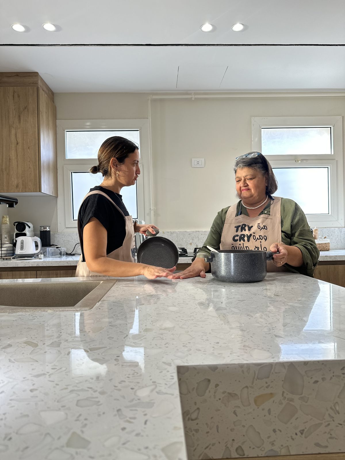 Teta Lolou cooking with her daughter, both in Lou's aprons