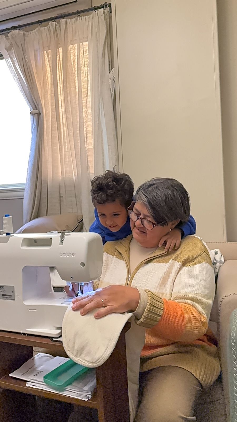 Teta Lolou at her sewing machine with her grandchild